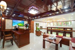sala de estar con TV, escritorio y mesa en Minh Quang Hotel, en Dong Hoi