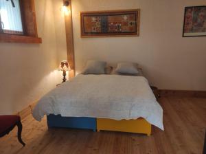 una camera da letto con un letto e un piumone bianco di B&B Max & Lory a Neviano degli Arduini