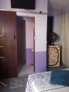 1 dormitorio con 1 cama y puerta al baño en Hostel e Pousada Boa Vista en Joinville