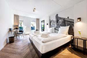 Oudewater的住宿－Broeck Oudewater，一间白色卧室,配有两张床和一张书桌