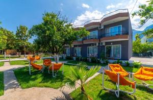 ein Haus mit orangefarbenen Stühlen davor in der Unterkunft Gızlıkoyhotel in Antalya