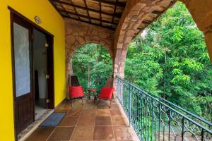 a balcony of a house with two chairs and a table at Pousada Canto No Bosque in Lençóis