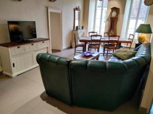 a living room with a green couch and a table at Gîte de la tour in Guillon