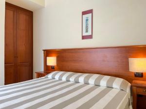 a bedroom with a bed with a wooden headboard at Albergo Degli Amici in Monterosso al Mare