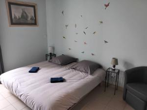 ein Schlafzimmer mit einem Bett mit zwei blauen Handtüchern darauf in der Unterkunft Gîte de la tour in Guillon