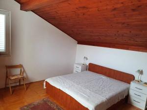een slaapkamer met een bed en een houten plafond bij Red Hill Beach House - stunning 3-story residence in Zaboric