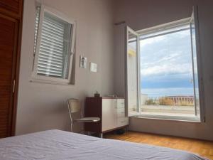 een slaapkamer met een bed, een bureau en een raam bij Red Hill Beach House - stunning 3-story residence in Zaboric