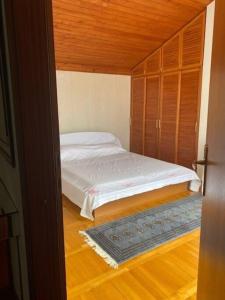 małą sypialnię z łóżkiem i drewnianą podłogą w obiekcie Red Hill Beach House - stunning 3-story residence w mieście Žaborić