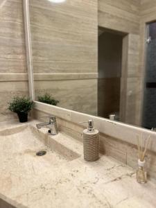 um balcão de casa de banho com um lavatório e um espelho em Stylish apartment with shared rooftop terrace/jacuzzi em Budapeste
