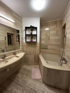uma grande casa de banho com banheira e lavatório em Stylish apartment with shared rooftop terrace/jacuzzi em Budapeste