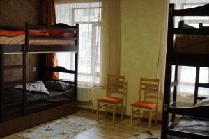 a room with bunk beds and two chairs and a window at Aragats Hostel & Guest House in Gyumri