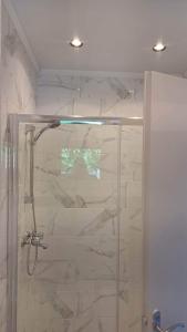 baño con ducha y puerta de cristal en Gregory's Village, en Plati