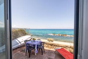 einen Tisch und Stühle auf einer Terrasse mit Meerblick in der Unterkunft Appartamento Pettinato in Pizzo