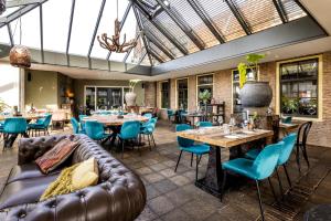 a restaurant with a leather couch and tables and chairs at Broeck Oudewater in Oudewater