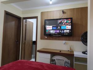 a bedroom with a flat screen tv on the wall at LagoMar Hostel in Florianópolis