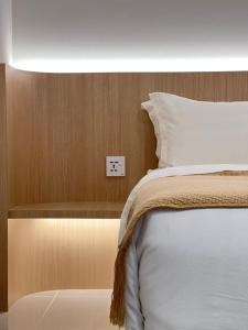 a bedroom with a bed and a light switch at The Shore CBD Kota Kinabalu By LAXZONE SUITE in Kota Kinabalu