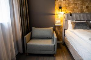 1 dormitorio con silla junto a la cama en Какао Апартамент Велинград, en Velingrad