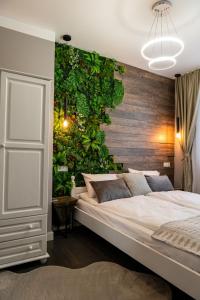 - une chambre avec un grand lit et un mur vert dans l'établissement Какао Апартамент Велинград, à Velingrad