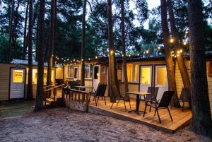 a cabin in the woods with a table and chairs at Pajūrio krantas Šventojoje in Palanga
