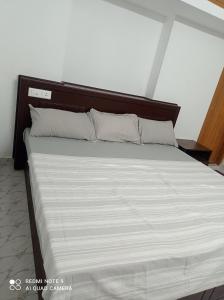 1 cama grande con cabecero de madera en una habitación en FAB HOUSE, en Thekkady
