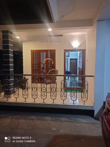 un balcón de una casa con sillas. en FAB HOUSE, en Thekkady