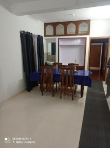 a dining room with a blue table and chairs at FAB HOUSE in Thekkady