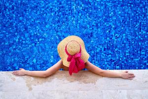a woman wearing a straw hat with a red bow at A Dream Place in Raanana, Spacious & Luxurious Apartment up to 4 guests - Swimming Pool in Ra‘ananna