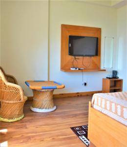 a room with a tv and a table and a bench at Ridhi Sidhi cottage in Kīar