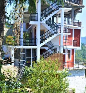 a building with stairs on the side of it at Ridhi Sidhi cottage in Kīar