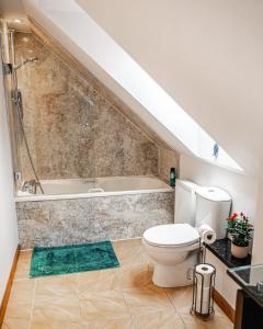 a bathroom with a toilet and a bath tub at Aldo's Place in Dingwall