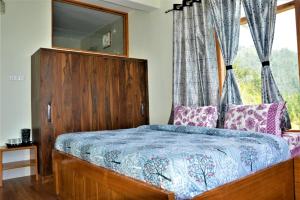 a bedroom with a wooden bed with a window at Ridhi Sidhi cottage in Kīar