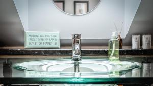 a bathroom sink with a soap dispenser and a mirror at Aldo's Place in Dingwall
