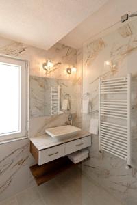 a white bathroom with a sink and a mirror at INES APARTMENTS in Ohrid