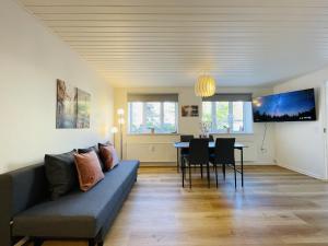 un soggiorno con divano e tavolo di aday - Charming apartment in the pedestrian street of Frederikshavn a Frederikshavn