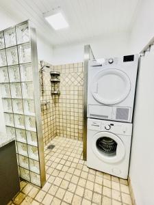 uma máquina de lavar roupa na casa de banho com um chuveiro em aday - Charming apartment in the pedestrian street of Frederikshavn em Frederikshavn