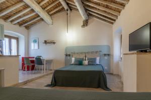 een slaapkamer met een bed en een flatscreen-tv bij A Casa Di Gaia in Riccò del Golfo di Spezia