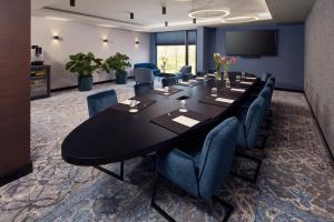 een vergaderzaal met een grote zwarte tafel en blauwe stoelen bij Hotel Gorinchem in Gorinchem