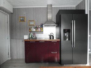 a kitchen with a black refrigerator and a sink at Linda's Apartment in Sörsjön