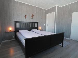 1 cama en una habitación con 2 lámparas en la pared en Linda's Apartment, en Sörsjön