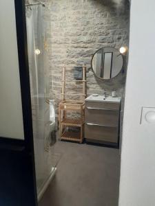 uma casa de banho com um lavatório e um espelho em CHEZ GUETOU Gîte de charme en Lozère em La Tieule