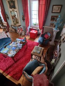 - un salon doté de meubles et d'un tapis rouge dans l'établissement Breizh & Breakfast, à Rosporden