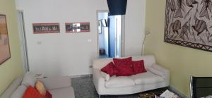 un soggiorno con divano bianco e cuscini rossi di Brighting Penthouse and balcony a Bari