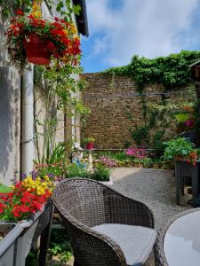 - une terrasse avec une table, des chaises et des fleurs dans l'établissement Breizh & Breakfast, à Rosporden