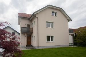 una casa blanca con un patio verde en Apartment Rozalija Žirovnica, en Žirovnica