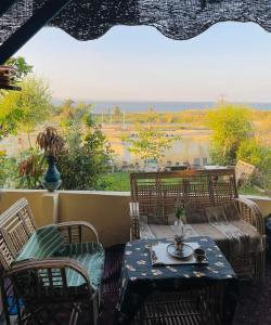 a patio with a table and chairs and a view of the water at Kayan House in Tunis