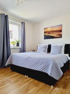 1 dormitorio con 1 cama grande y cortinas azules en Hübsches Design Apartment mit Parkplatz im Zentrum von Königstein en Königstein an der Elbe