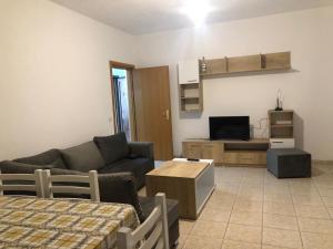 sala de estar con sofá y TV en Apartament rohelio shkembi kavajes en Durrës