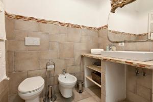 a bathroom with a toilet and a sink and a mirror at Antoglietta 19 Old Town - Lecce Selection in Lecce +35 photos