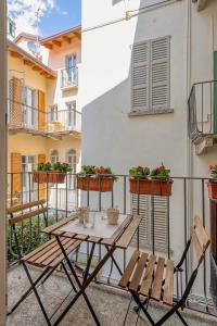 un patio con tavolo e panche sul balcone di Boutique Apartment Porta Duomo, close to the lake! a Como