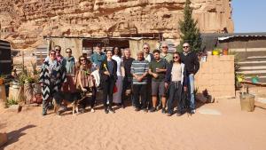 a group of people posing for a picture in front of a mountain at Martian desert Camp in Wadi Rum